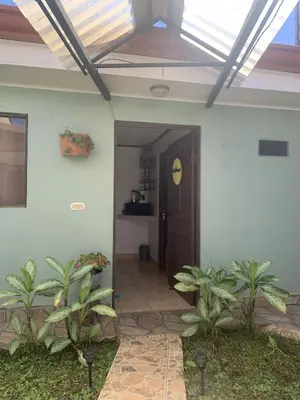 an open door to a house with a solar roof at Rincón Poeta in San Ramón