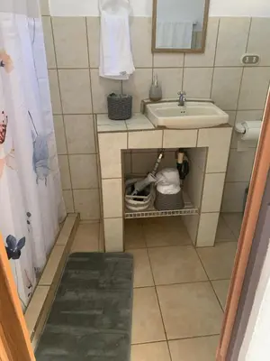 a small bathroom with a sink and a mirror at Rincón Poeta in San Ramón