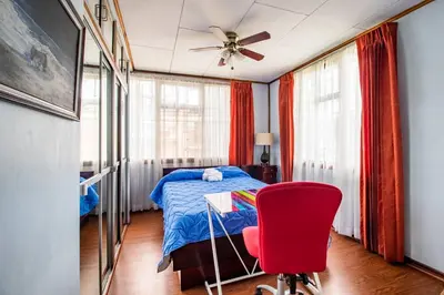 a bedroom with a bed and a red chair at Vilma Friendly Guesthouse - RB in San José