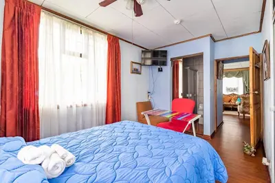 a bedroom with a blue bed and a red chair at Vilma Friendly Guesthouse - RB in San José