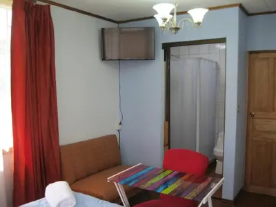 a living room with a couch and a red chair at Vilma Friendly Guesthouse - RB in San José