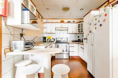 a kitchen with white cabinets and a white refrigerator at Vilma Friendly Guesthouse - RB in San José