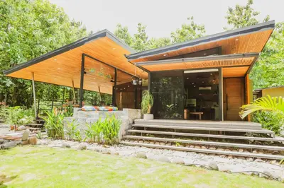 a house with a glass door and stairs in a yard at Avellanas Private Villa in Santa Cruz