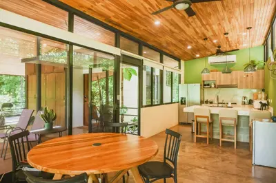 a kitchen and dining room with a wooden table and chairs at Avellanas Private Villa in Santa Cruz