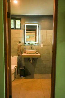 a bathroom with a sink and a toilet and a mirror at Avellanas Private Villa in Santa Cruz