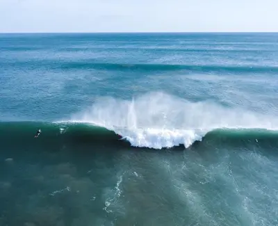 a surfer riding a wave in the ocean at Avellanas Private Villa in Santa Cruz