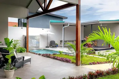 an external view of a house with a swimming pool at Calathea Arenal Villa in Agua Azul