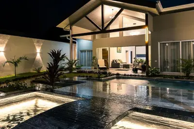 a house with a swimming pool in the rain at Calathea Arenal Villa in Agua Azul