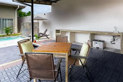 a wooden table and chairs on a patio at Calathea Arenal Villa in Agua Azul