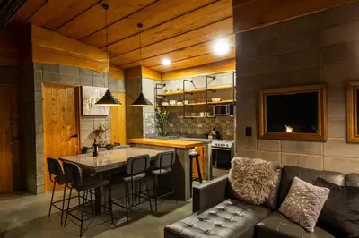 a kitchen and living room with a couch and a table at Cabaña Moderna de Montaña en Zarcero con Vistas y Bosque Neblinoso in Zarcero