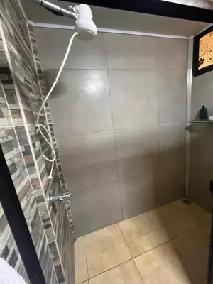 a shower in a room with a wall at Tu casa de habitación en Sarapiquí, Costa Rica in Pedregal