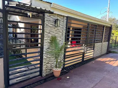 a building with a fence and a potted plant at Tu casa de habitación en Sarapiquí, Costa Rica in Pedregal