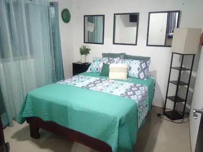 a bedroom with a bed with a green comforter at Fruta de mango #2 in Lagunillas