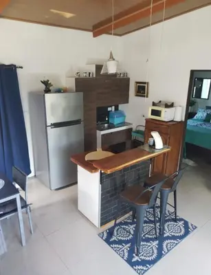 a small kitchen with a refrigerator and a table and chairs at Fruta de mango #2 in Lagunillas