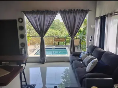 a living room with a couch and a large window at Fruta de mango #2 in Lagunillas