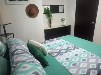 a bedroom with a bed with a blanket and a plant at Fruta de mango #2 in Lagunillas