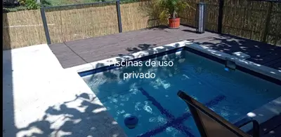 a swimming pool with a wooden deck and a sign on it at Fruta de mango #2 in Lagunillas