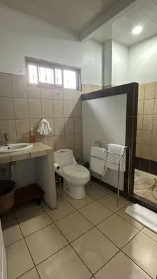a bathroom with a toilet and a sink at Valle del Arenal House Family Home in La Fortuna in Fortuna