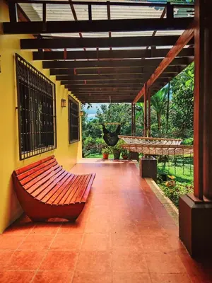 a patio with a bench on the side of a house at Valle del Arenal House Family Home in La Fortuna in Fortuna