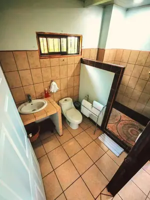 a bathroom with a toilet and a sink at Valle del Arenal House Family Home in La Fortuna in Fortuna