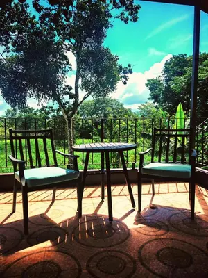 a picnic table and two benches sitting on a patio at Valle del Arenal House Family Home in La Fortuna in Fortuna