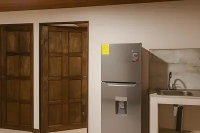 a kitchen with a refrigerator and a sink at Fraijanes Mountain Stay in Alajuela City