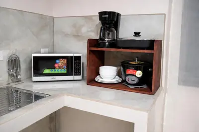a kitchen counter with a microwave and a coffee maker at Fraijanes Mountain Stay in Alajuela City