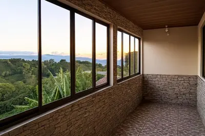 a room with windows with a view of the mountains at Fraijanes Mountain Stay in Alajuela City