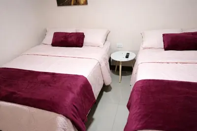 two beds sitting next to each other in a room at Fraijanes Mountain Stay in Alajuela City