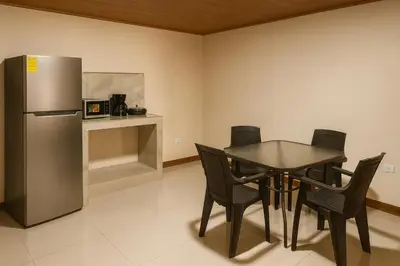 a dining room with a table and a refrigerator at Fraijanes Mountain Stay in Alajuela City