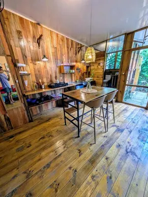 a dining room with a table and wooden floors at Arbura in Uvita
