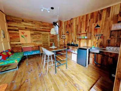 a kitchen with wooden walls and a couch and a table at Arbura in Uvita