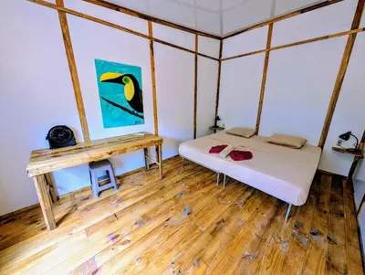 a small room with a bed and a table at Arbura in Uvita
