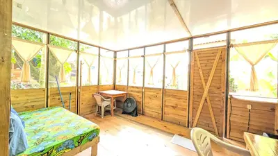 a room with a bed and a table and windows at Arbura in Uvita