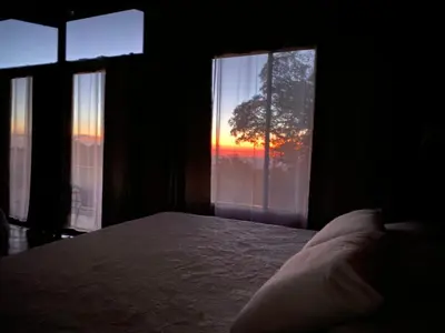 a bedroom with a bed and a window with a sunset at Tamara Monteverde View and Forest Chalet in Monteverde Costa Rica
