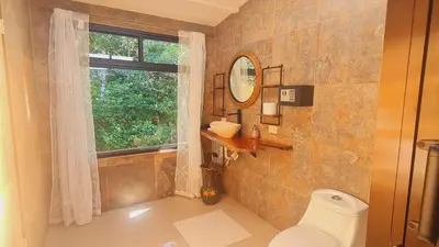 a bathroom with a toilet and a window and a sink at Tamara Monteverde View and Forest Chalet in Monteverde Costa Rica