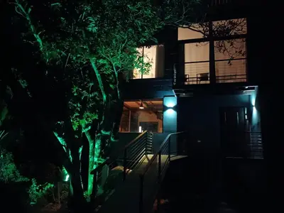 a house lit up at night with green lights at Tamara Monteverde View and Forest Chalet in Monteverde Costa Rica