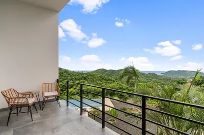 a balcony with two chairs and a view of the mountains at Villas Vivo in Potrero