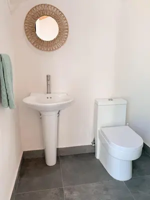 a bathroom with a sink and a toilet and a mirror at Villas Vivo in Potrero