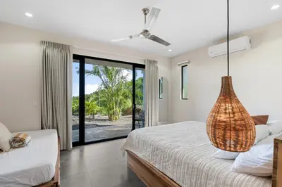 a bedroom with a bed and a large window at Villas Vivo in Potrero