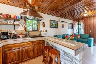 a kitchen with a bar and a couch in a room at Toucan River Paradise - River access, AC in Fortuna