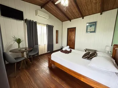 a bedroom with a bed and a table and chairs at Habitación doble, Hotel Aurora Inn, Nuevo Arenal in Nuevo Arenal