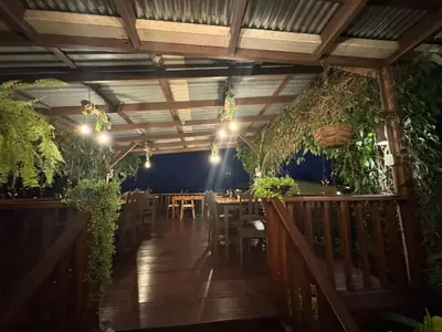 a restaurant with tables and chairs and plants at Habitación doble, Hotel Aurora Inn, Nuevo Arenal in Nuevo Arenal