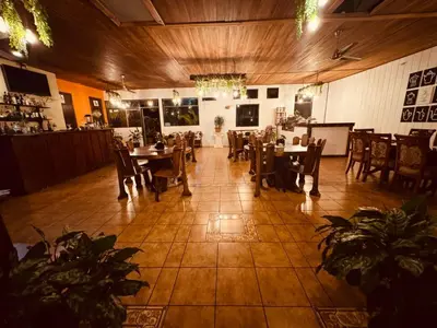 a dining room with tables and chairs in a room at Habitación doble, Hotel Aurora Inn, Nuevo Arenal in Nuevo Arenal