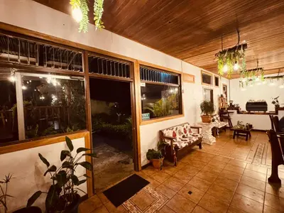 a living room with large windows and a couch at Habitación doble, Hotel Aurora Inn, Nuevo Arenal in Nuevo Arenal