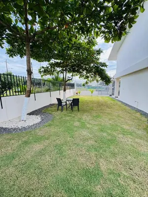 a table and chairs under a tree next to a building at Modern Home Near Playa Bandera Great Location in Parrita