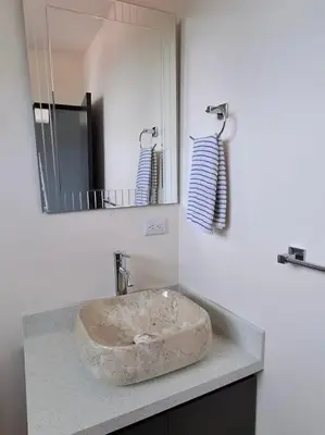 a bathroom with a stone sink and a mirror at Modern Home Near Playa Bandera Great Location in Parrita