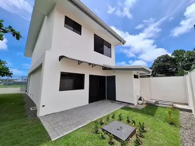 a white house with a green yard at Modern Home Near Playa Bandera Great Location in Parrita