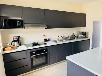a kitchen with black cabinets and a sink at Modern Home Near Playa Bandera Great Location in Parrita