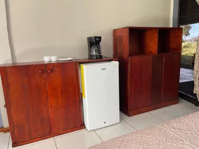 a kitchen with wooden cabinets and a white refrigerator at Little Paradise in Nuevo Arenal